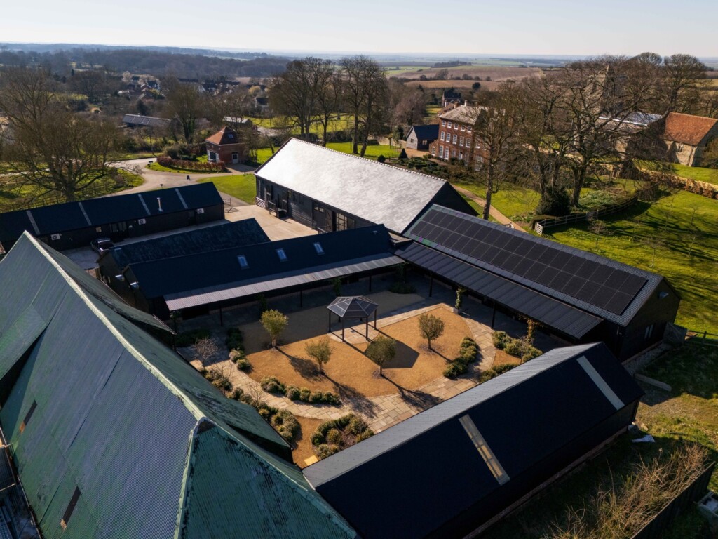 Aerial view of solar panels across a barn conversion complex