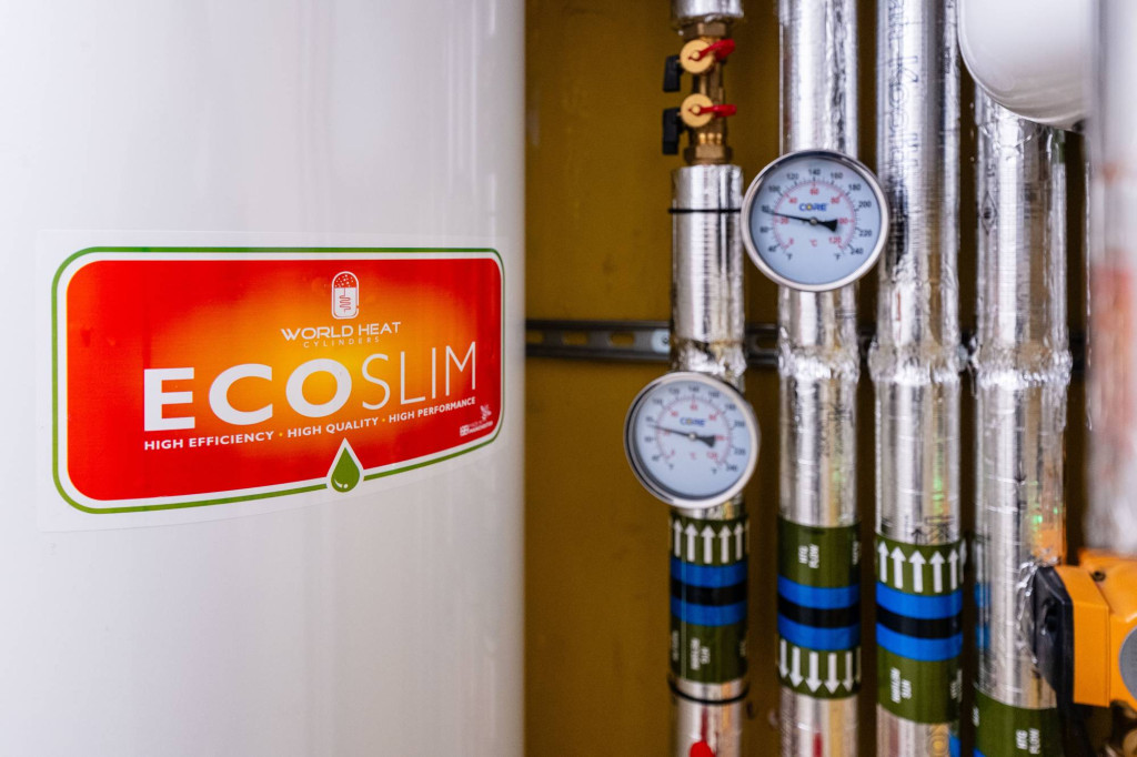 EcoSlim hot water cylinder beside heat pump pipework