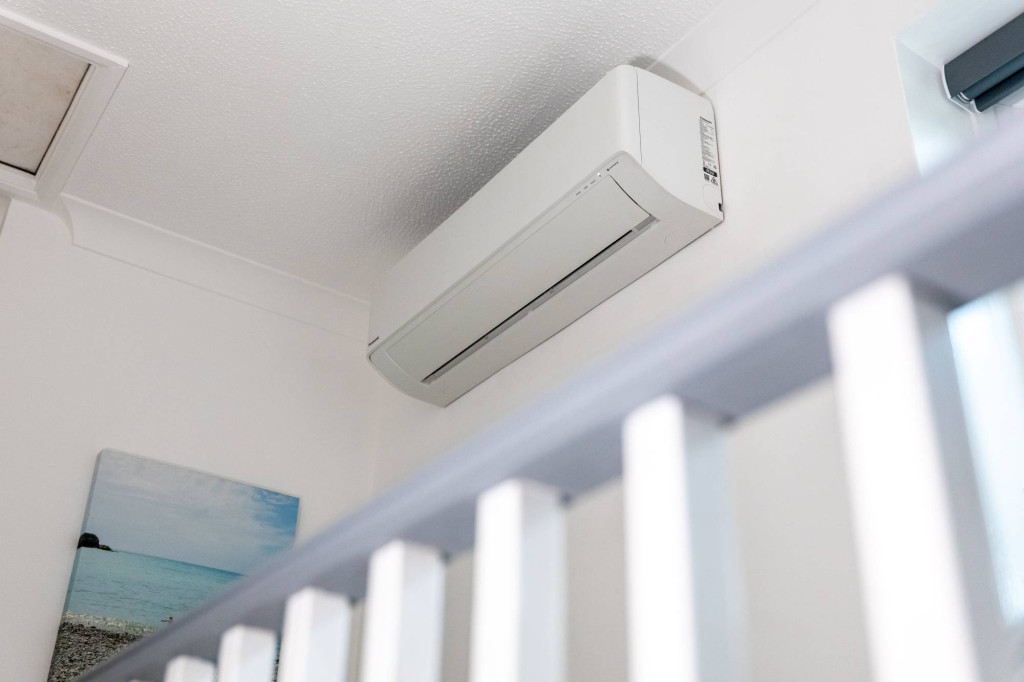 Wall-mounted air conditioning unit above a staircase
