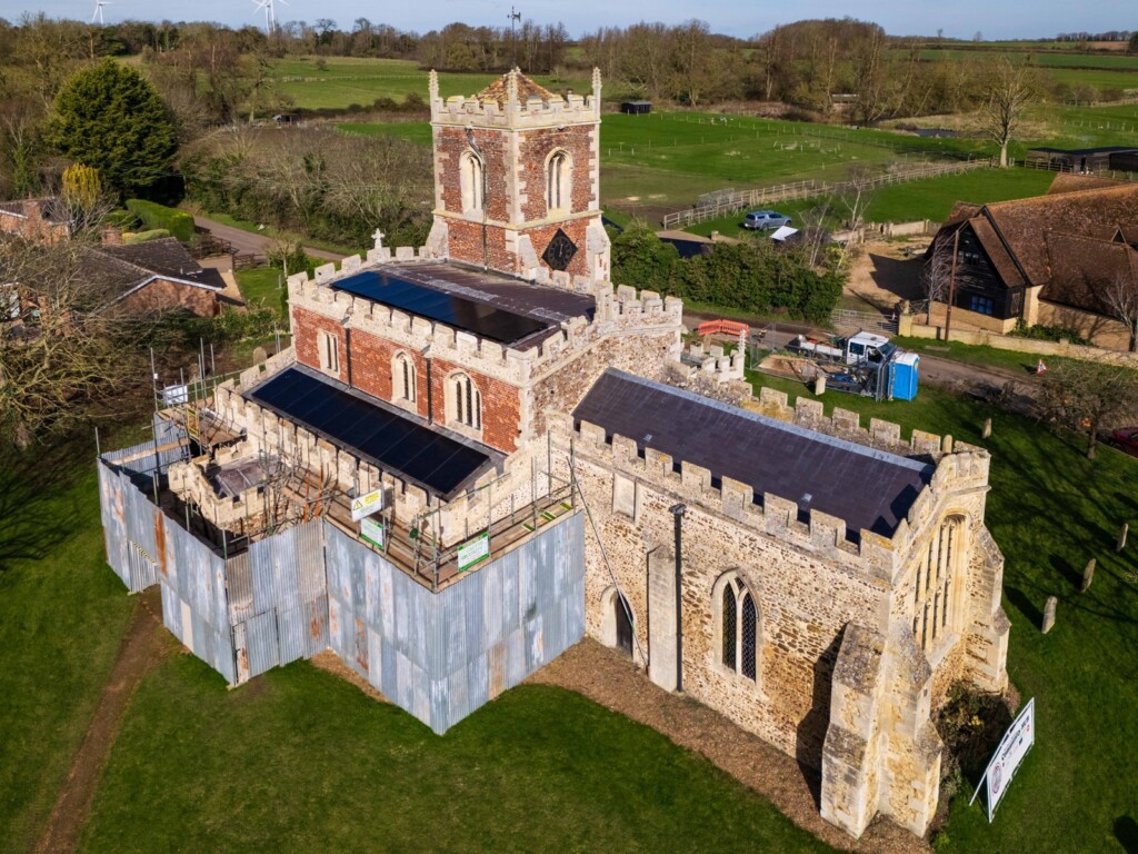 Aerial view of solar panels being installed on a church roof in Cambridgeshire