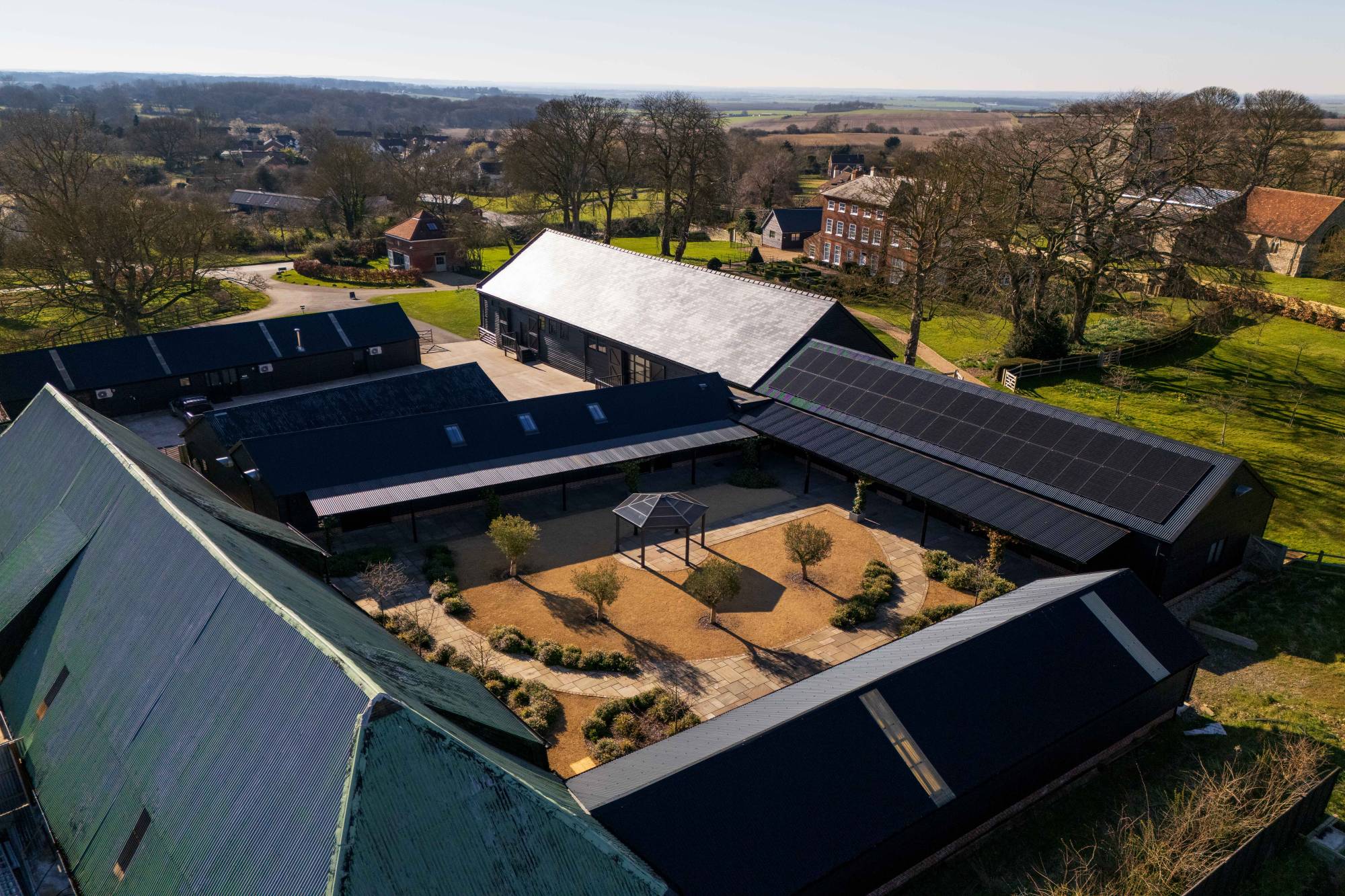 Aerial view of solar panels across the barn roofs at Sandon Manor
