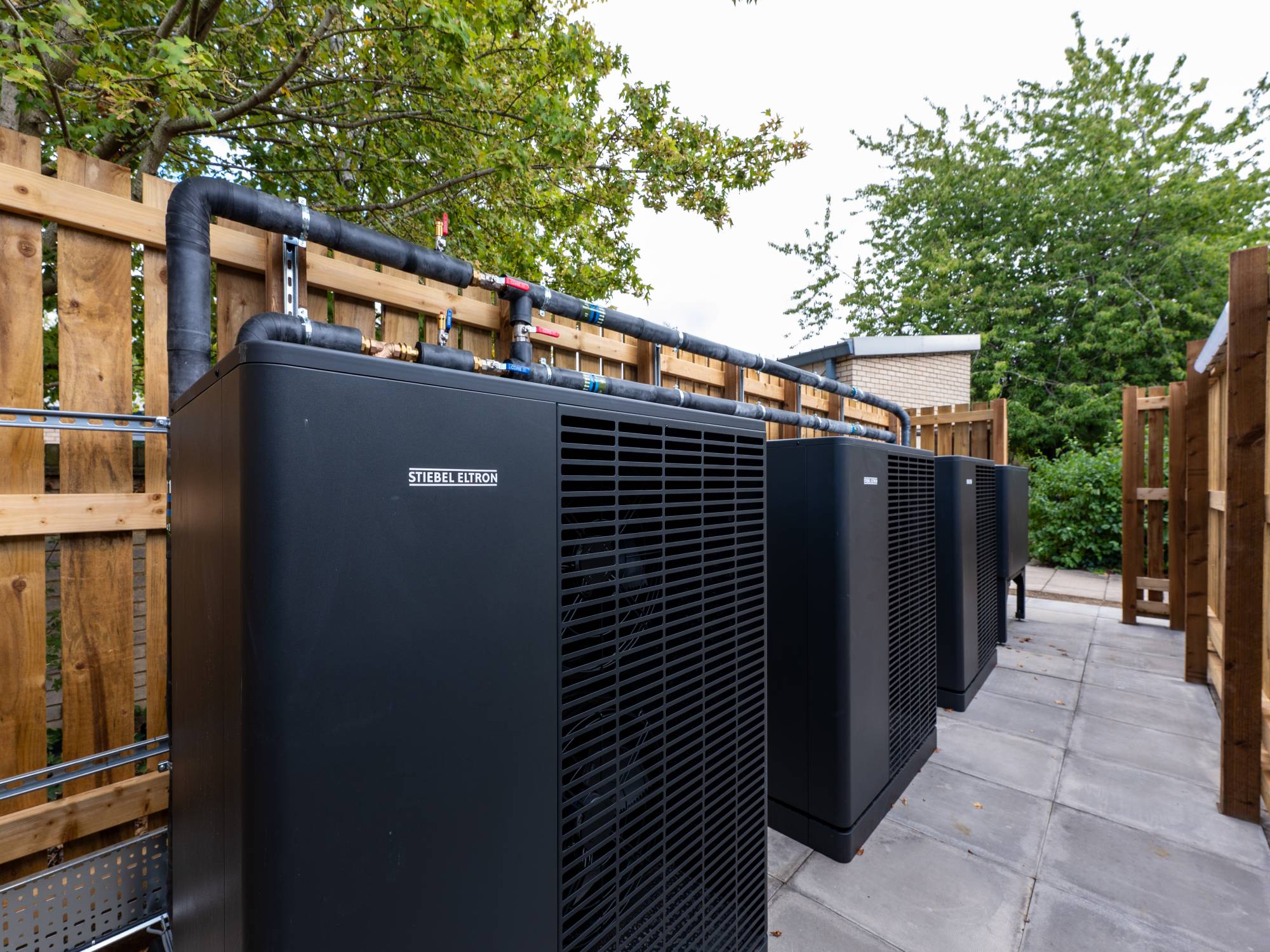 Row of Stiebel Eltron air source heat pumps in the plant compound at a Cambridge nursery