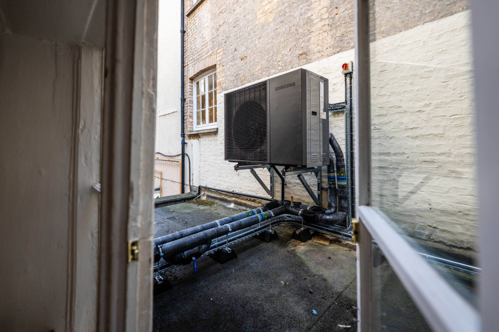 Air source heat pump installed in a courtyard at historic Cambridge student accommodation